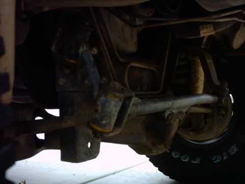 1990 Ford Bronco - This photo shows the undercarriage of a vehicle, focusing on the suspension and frame. A tire with 'BIG FOOT' branding is visible.