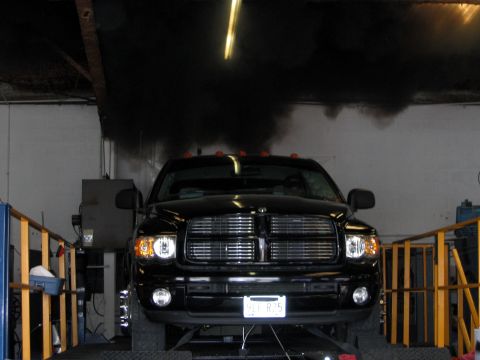 2000 Ford Crown Victoria - A black pickup truck is shown on a dynamometer, producing a large cloud of black smoke.