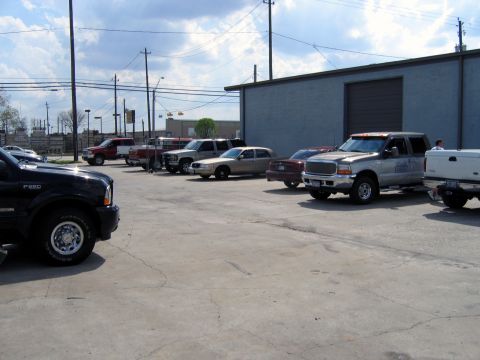 2000 Ford Crown Victoria - A gold 2000 Ford Crown Victoria is parked in a lot with other vehicles under a cloudy sky.