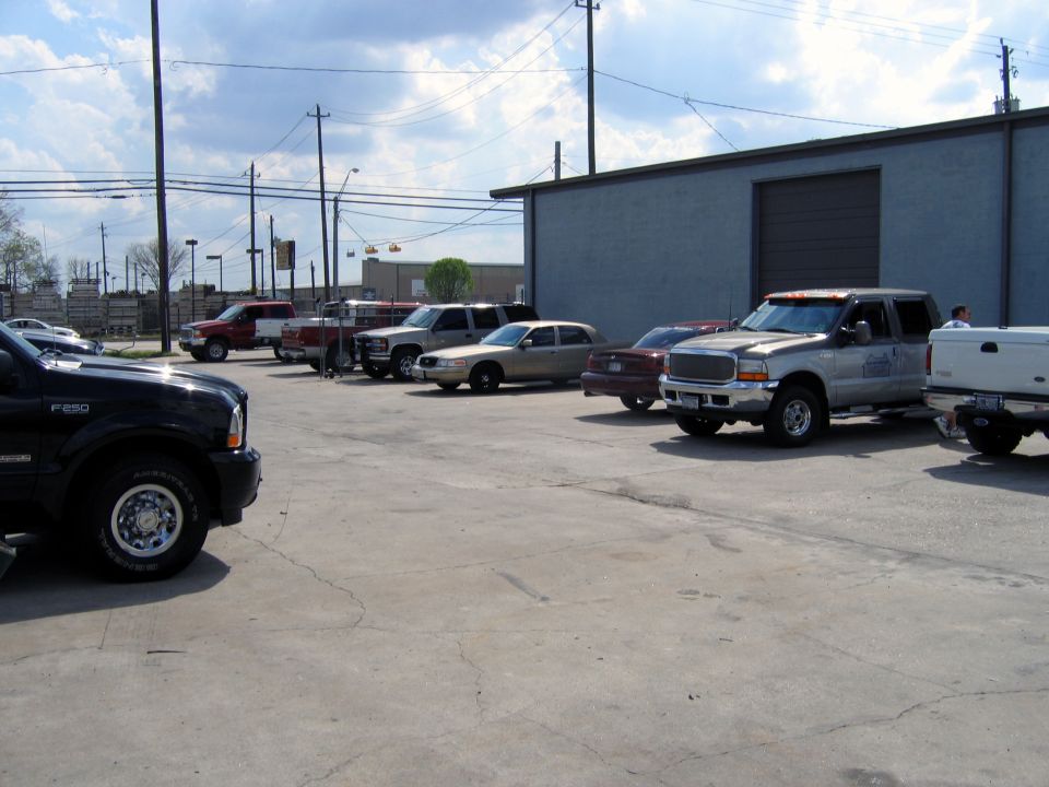 Gold 2000 Ford Crown Victoria parked on concrete, side view, with visible damage on the rear bumper