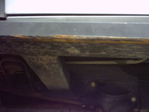 1990 Ford Bronco - Underside of vehicle frame showing rust and suspension parts. SUPERMOTORS watermark present.