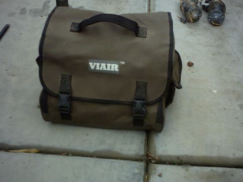 1990 Ford Bronco - Viair tool bag and starter motors are shown on a concrete surface.