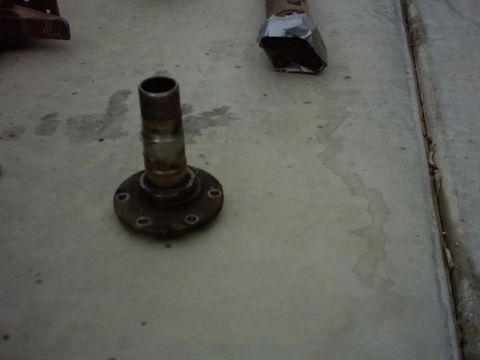 1990 Ford Bronco - A close-up view of a used wheel hub assembly resting on a concrete surface.