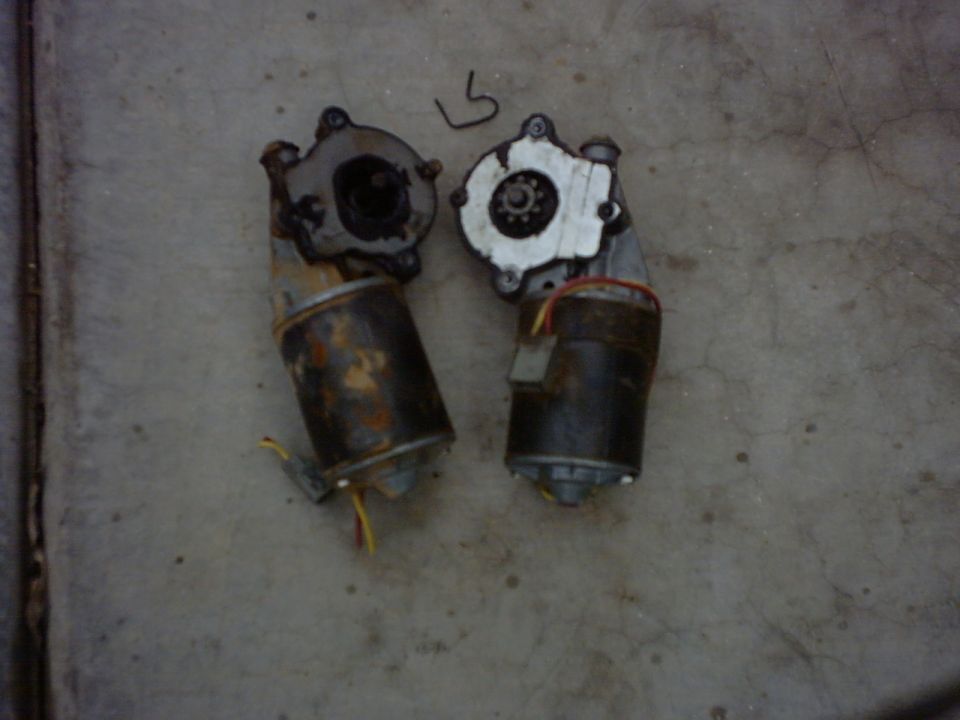 Two windshield wiper motors on concrete