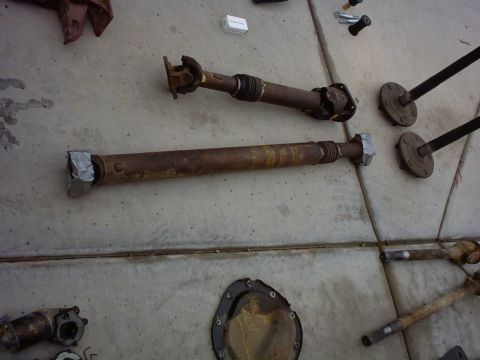 1990 Ford Bronco - Driveshafts and differential components laid out on a concrete surface.