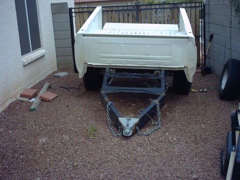 1990 Ford Bronco - Pickup truck bed, mounted on a trailer frame, is hitched to a trailer tongue.
