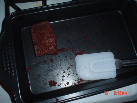 1993 Ford Taurus - A single brownie remains in a baking pan, with crumbs scattered around and a spatula nearby.