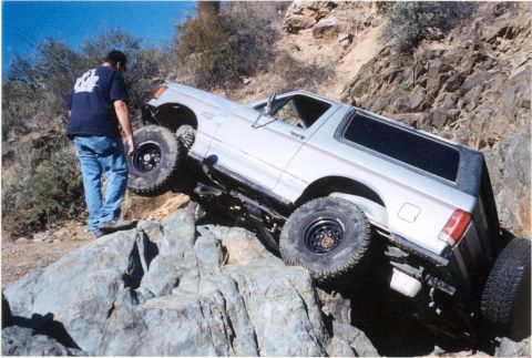 1990 Ford Bronco - Ford Bronco navigating difficult rocky terrain during an off-road excursion.