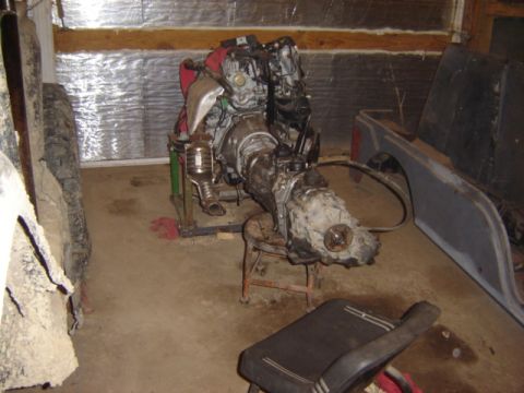 1992 Ford Bronco - An engine and transmission assembly is displayed on a stand in a garage setting.