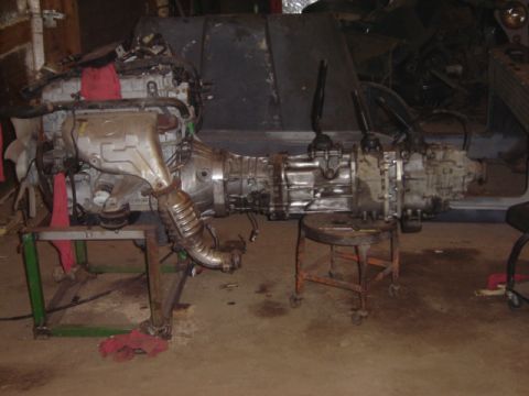1992 Ford Bronco - Engine and transmission assembly on stands in a workshop.