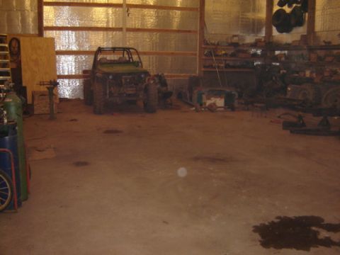 1992 Ford Bronco - An off-road vehicle sits in a cluttered garage, surrounded by tools and parts.