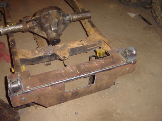 Rusty vehicle frame section with rear axle assembly and welded metal plate