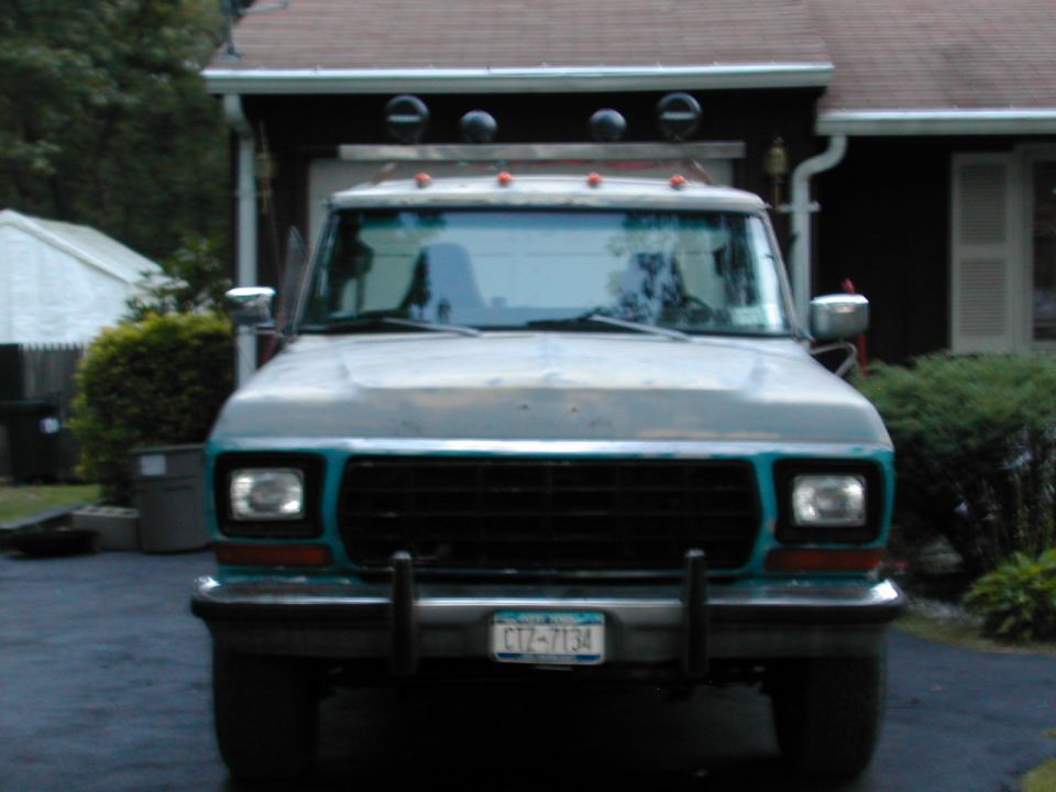 Front view of teal and white 1970s Ford truck with roof lights and NY plate CTZ-7134 in driveway