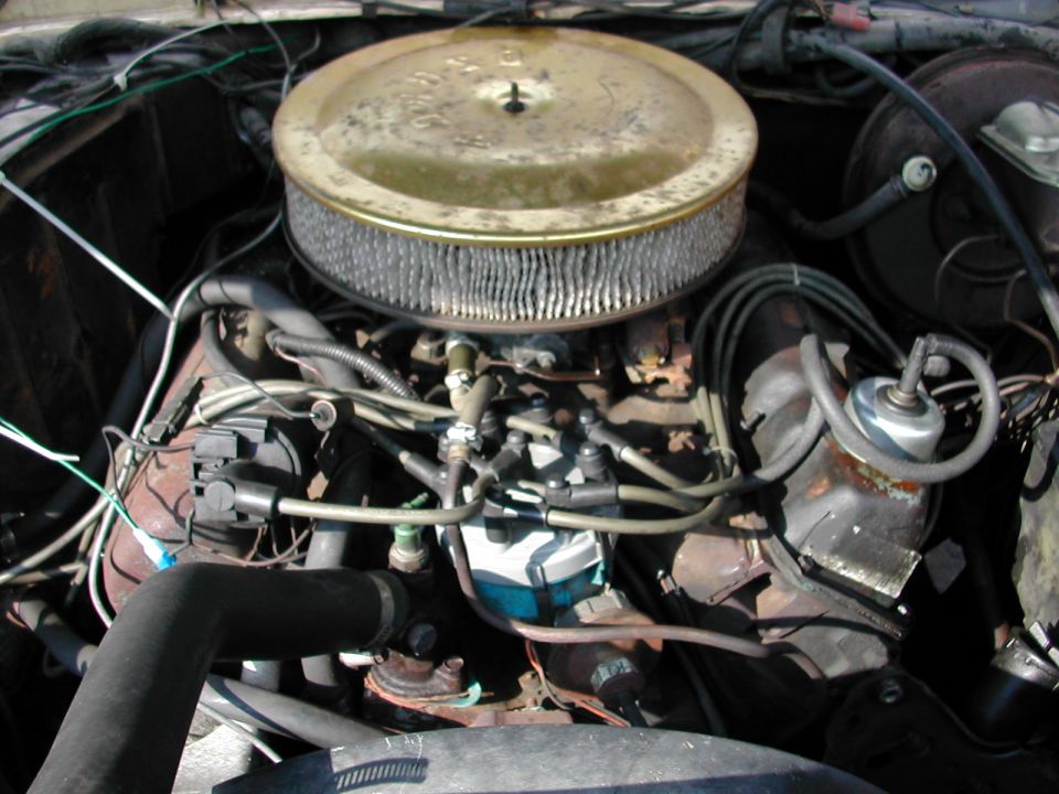V8 engine bay with large round gold air cleaner, carburetor, and aged wiring