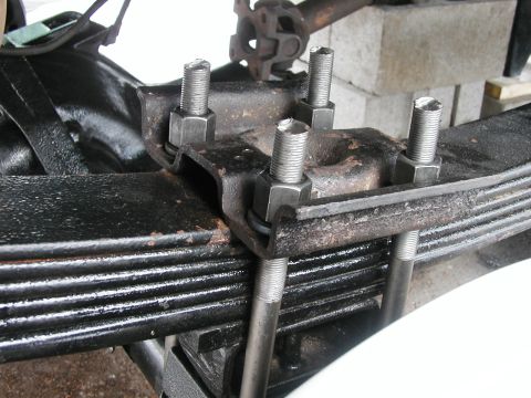 1994 Ford Bronco - Close-up of a vehicle's leaf spring suspension system, highlighting the U-bolts and mounting hardware.