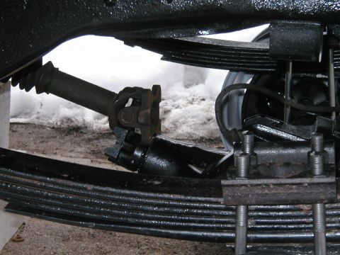 1994 Ford Bronco - Close-up view of the driveshaft U-joint and leaf springs on a vehicle.