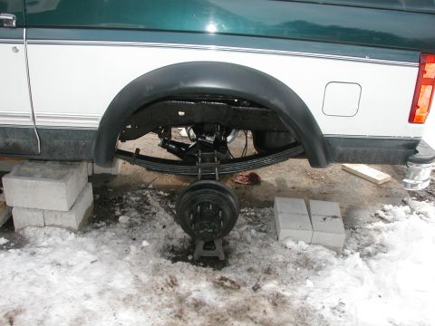 1994 Ford Bronco - 1994 Ford Bronco rear suspension work in progress, wheel removed and vehicle supported by jack stands.