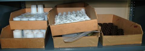 2000 Ford Mustang - Several cardboard boxes filled with various small parts are organized on metal shelving units.