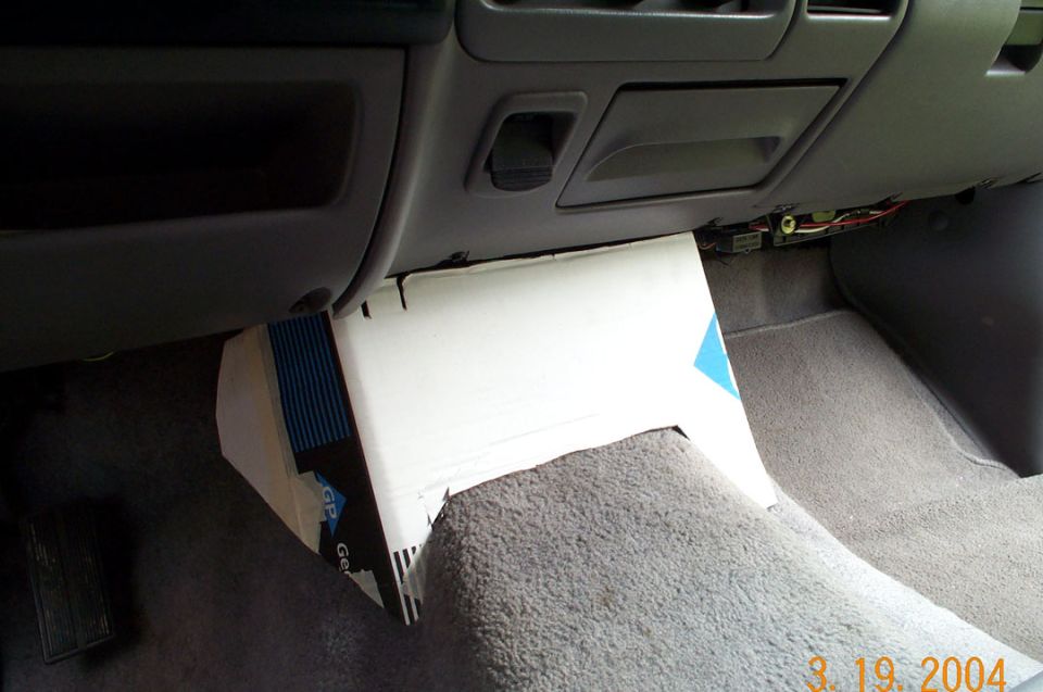 Cardboard template mockup in gray Ford truck passenger footwell with exposed dash wiring