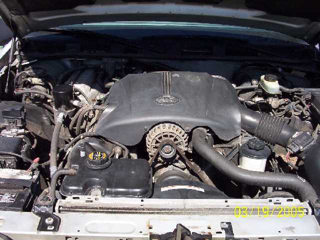 Engine bay with V8 engine cover, alternator, and coolant reservoir visible. Date stamp reads 02/19/2005
