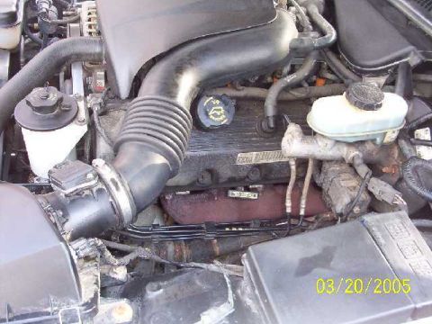1999 Ford Crown Victoria - Engine bay of a 1999 Ford Crown Victoria, showing various components and a date stamp.