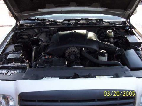 1999 Ford Crown Victoria - The engine bay of a 1999 Ford Crown Victoria is visible with the hood open, displaying the engine and associated parts.