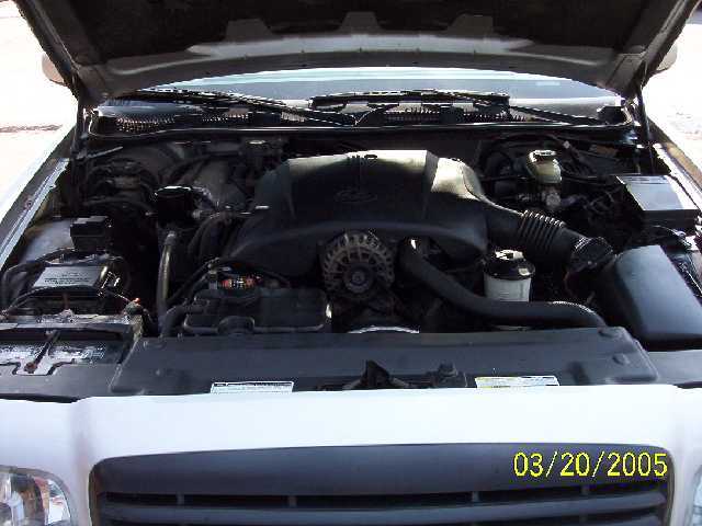 Engine bay of a 1999 Ford Crown Victoria. Shows the engine, battery, and other components under the hood