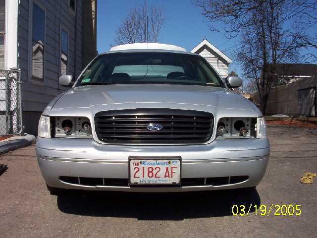 Silver 1999 Ford Crown Victoria front view, missing headlights