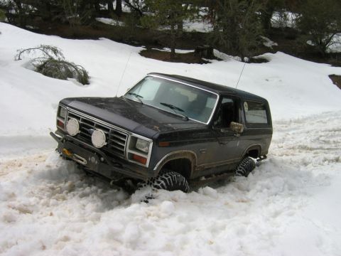 1985 Ford Bronco - This 1985 Ford Bronco is stuck in deep snow, showing its front end and tires.