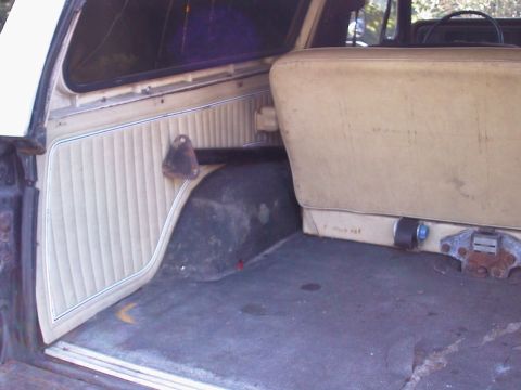 1979 Ford Bronco - The interior cargo area of a 1979 Ford Bronco shows tan upholstery and ribbed side panels.