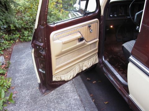 1979 Ford Bronco - The interior of a 1979 Ford Bronco shows its door panel and dashboard details.