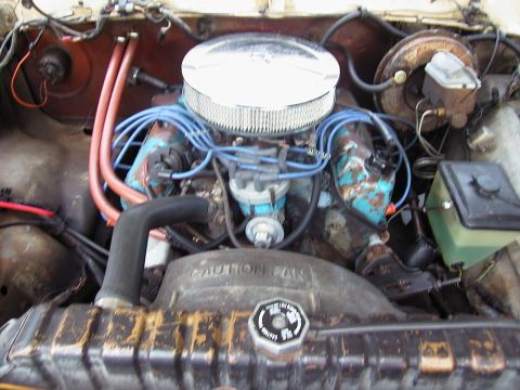 1979 Ford Bronco - The engine bay of a vehicle, showing the V8 engine components and radiator. A "CAUTION FAN" warning is visible on the fan shroud.
