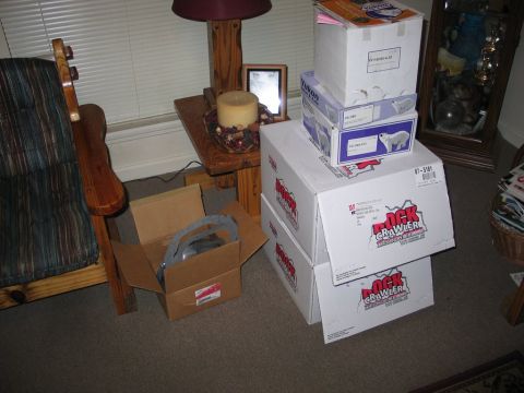 1989 Ford F-150 - Several boxes, some labeled 'Rock Crawler', are stacked indoors near a chair and a table with a lamp.
