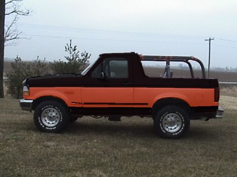 1994 Ford Bronco - This 1994 Ford Bronco features a distinctive two-tone paint scheme with orange on the lower half and black on the upper half.