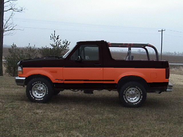 Side view of a 1994 Ford Bronco, two-tone orange and black