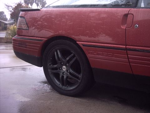 1989 Ford Probe - The side panel of a red car displays a "TURBO" badge, but the year is not visible.