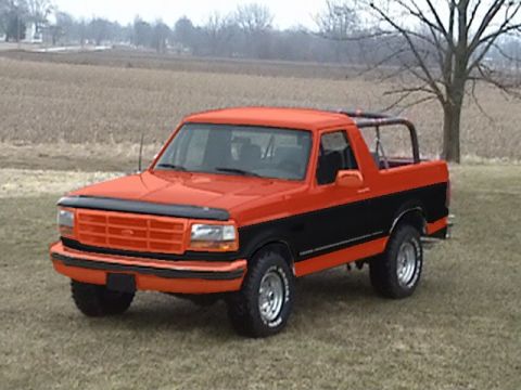 1994 Ford Bronco - 1994 Ford Bronco with a two-tone paint job sits in a grassy field.