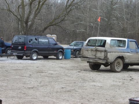 1992 Ford Bronco - This muddy Ford Bronco is parked in an outdoor lot with other vehicles and portable toilets.