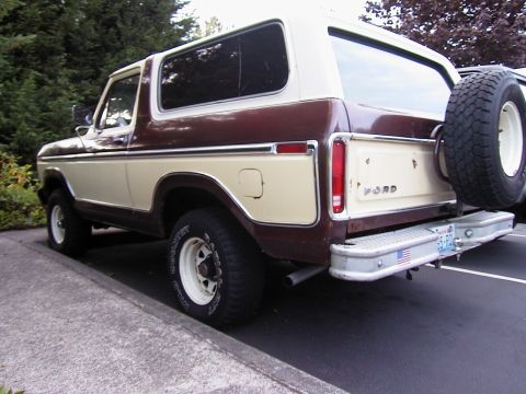 1979 Ford Bronco - Rear three-quarter view of a two-tone brown and tan late-1970s full-size Ford Bronco with a removable hardtop, showing the FORD-lettered ta…