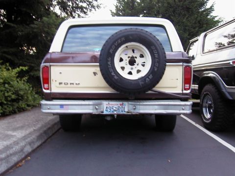 1979 Ford Bronco - Rear view of a two-tone brown-and-cream full-size Ford Bronco with a body-color hardtop, a Dunlop Radial Rover spare on a white spoke wheel…