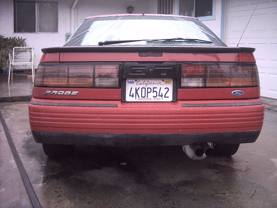 Rear of red Ford Probe coupe with California plate 4KOP542 on wet driveway