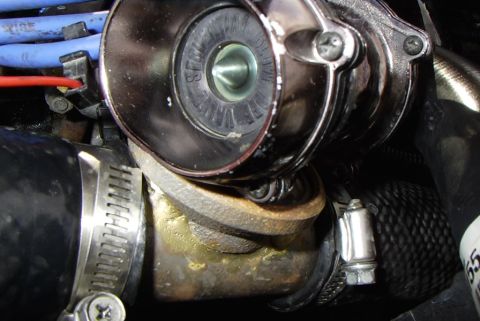 1989 Ford Probe - Close-up view of a chrome turbocharger bypass valve with blue spark plug wires visible.