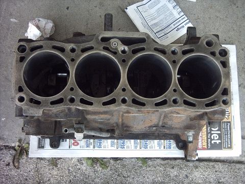 1989 Ford Probe - A four-cylinder engine block is shown, placed on top of a newspaper for support.