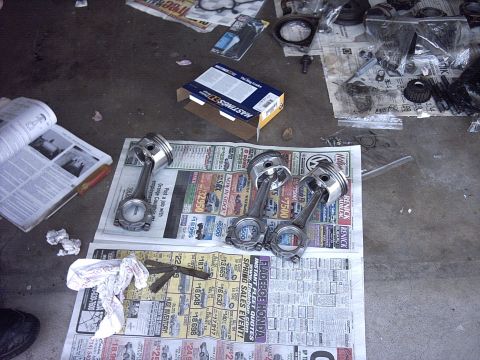 1989 Ford Probe - Engine parts are laid out on the floor, possibly for repair or inspection, with a manual and a box of parts visible.