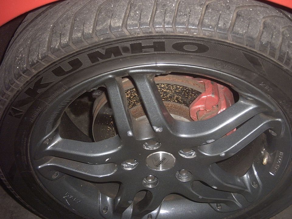Close-up of a car wheel with Kumho tire and red brake caliper