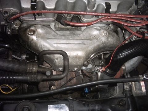 1989 Ford Probe - Close-up view of an engine bay, highlighting the turbocharger and exhaust manifold with red Magnecor KV85 Competition spark plug wires.