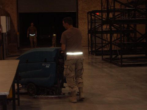 1988 Ford Bronco - A man in tactical pants operates a floor cleaning machine inside a warehouse.