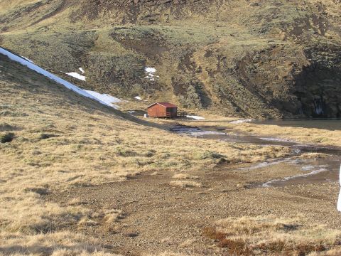 2001 Jeep Wrangler - A remote cabin is situated in a , natural landscape with sparse vegetation and melting snow.