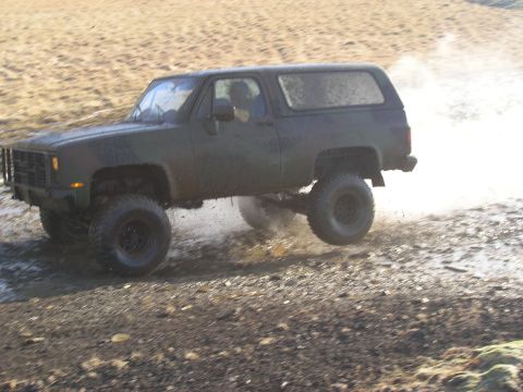 2001 Jeep Wrangler - This SUV is shown in a three-quarter front view while navigating a muddy, off-road terrain.