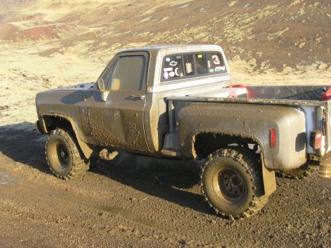 2001 Jeep Wrangler - This pickup truck is covered in mud after driving off-road.